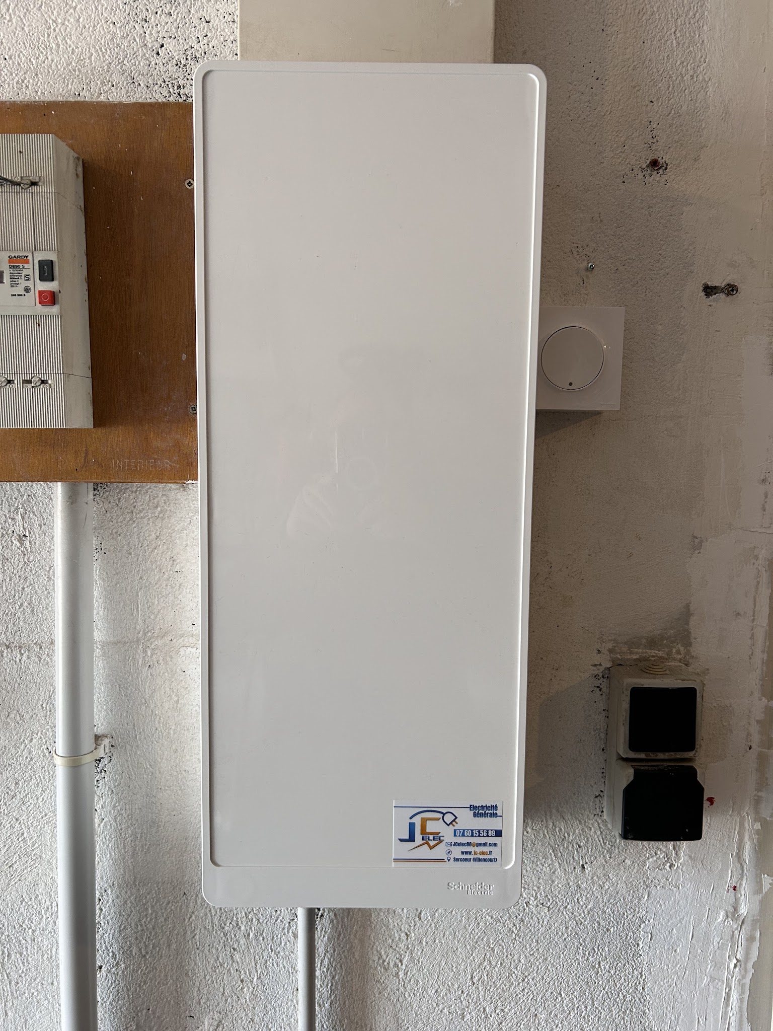 Tableau électrique fermé avec l'étiquette JC Elec
